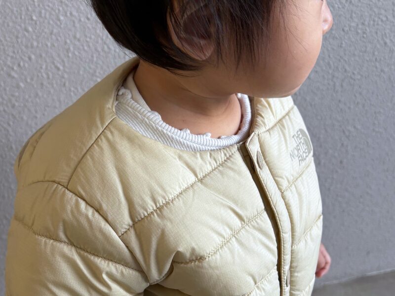 ノースフェイス ベビーダウン マイクロゼファーカーディガンを着用した際の首元アップの写真